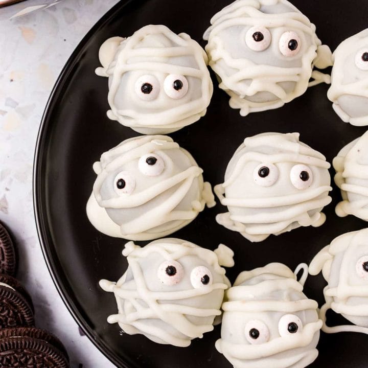 Easy Mummy Oreo Truffles on a black plate for halloween