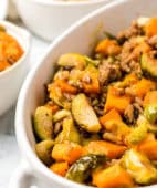 Roasted Brussels Sprouts And Sweet Potatoes close up in a white serving dish
