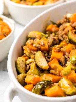 Roasted Brussels Sprouts And Sweet Potatoes close up in a white serving dish