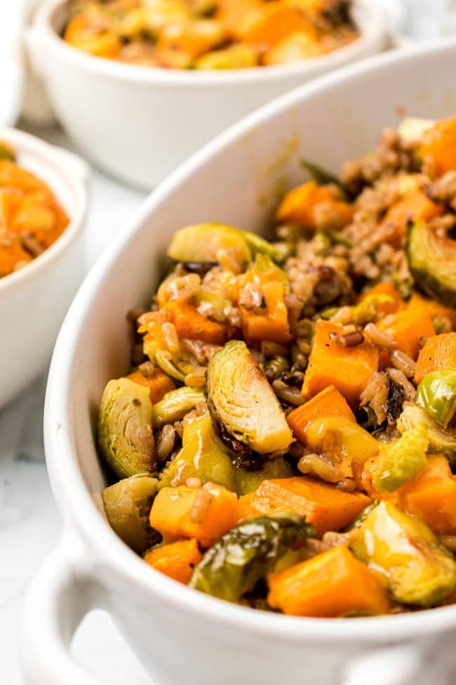 Roasted Brussels Sprouts And Sweet Potatoes close up in a white serving dish 