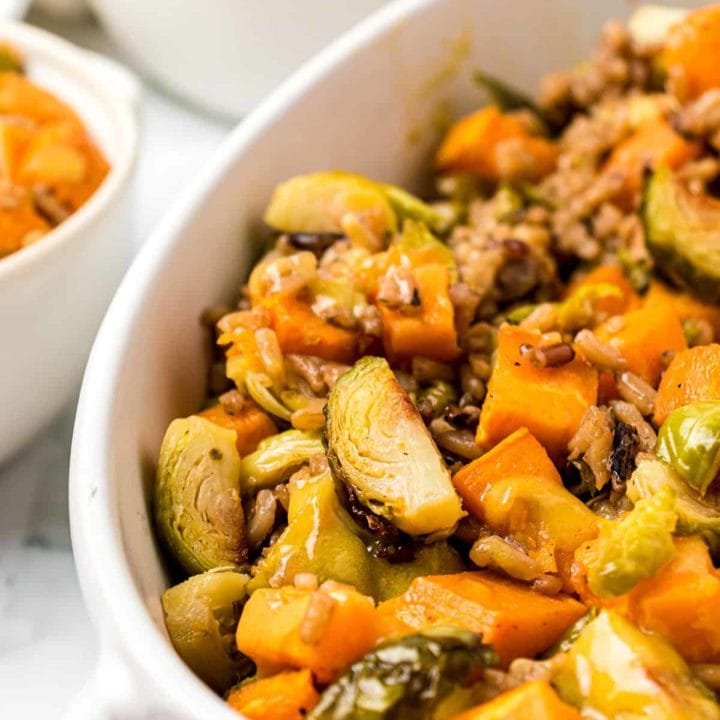 Roasted Brussels Sprouts And Sweet Potatoes close up in a white serving dish