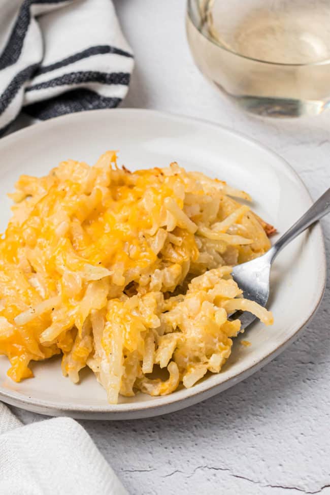 plate of cheesy potato casserole with a fork