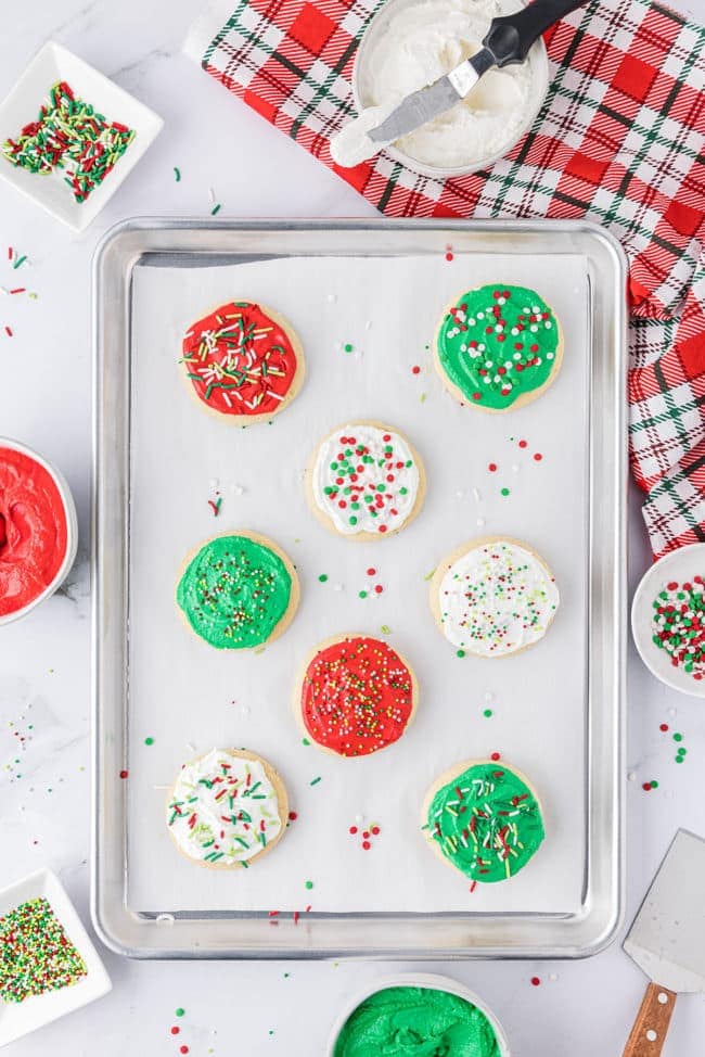 a pan of baked and frosted Christmas sugar cookies in red, green and white.