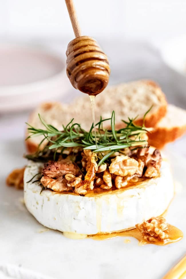 baked brie wheel with honey drizzle and fresh rosemary