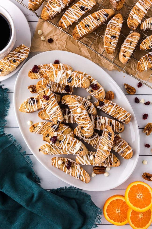 a platter of biscotti with white chocolate drizzle