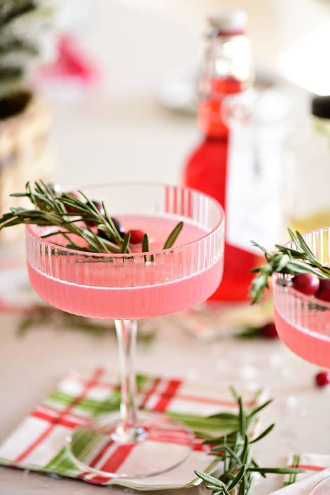 pretty pink holiday cosmopolitan cocktails with fresh cranberries and rosemary