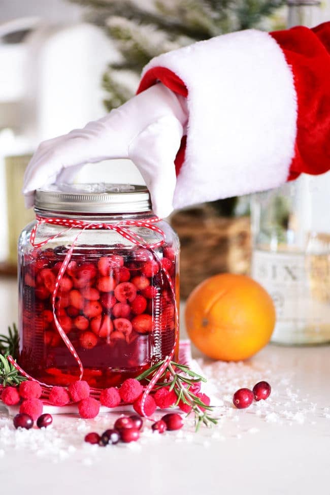 Santa grabbing a large jar of cranberry infused vodka