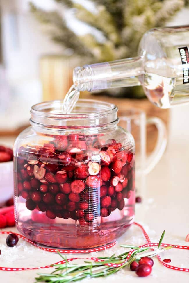 pouring vodka over fresh cranberries