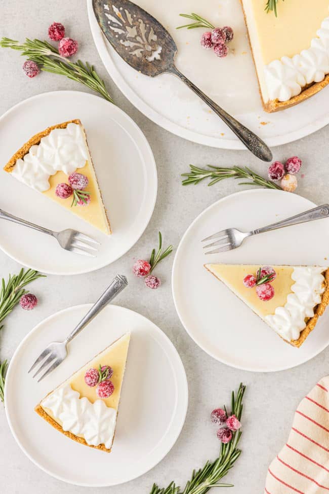 overhead shot of 4 slices of cheesecake on plates with a fork