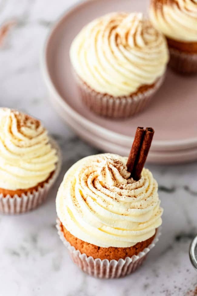 overhead shot of eggnog cupcakes with cinnamon stick in frosting