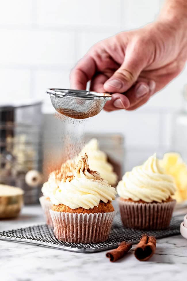 dusting cupcakes with cinnamon