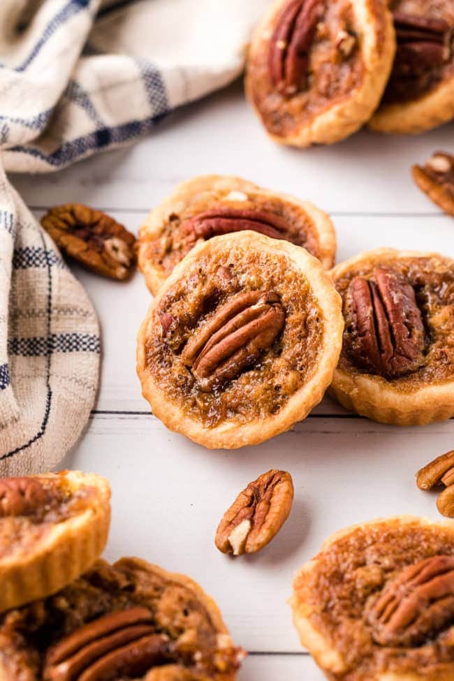 mini pecan pies on a table with a blue and tan napkin