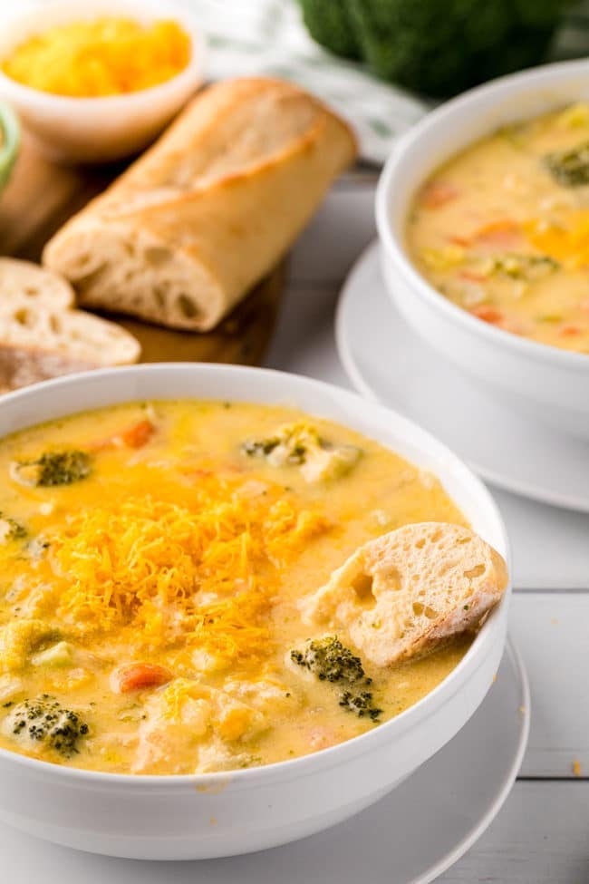 a warm bowl of broccoli cheddar soup with a piece of rustic bread