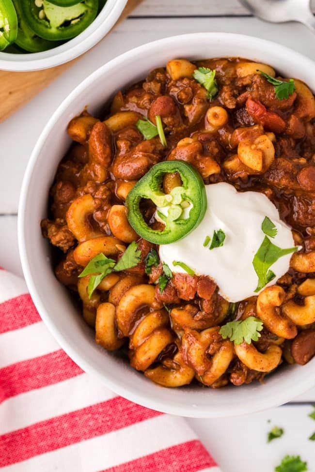 close up of a bowl of chili with macaroni pasta and cheese