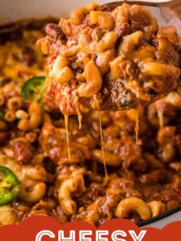 close up of a wooden spoon full of cheesy chili