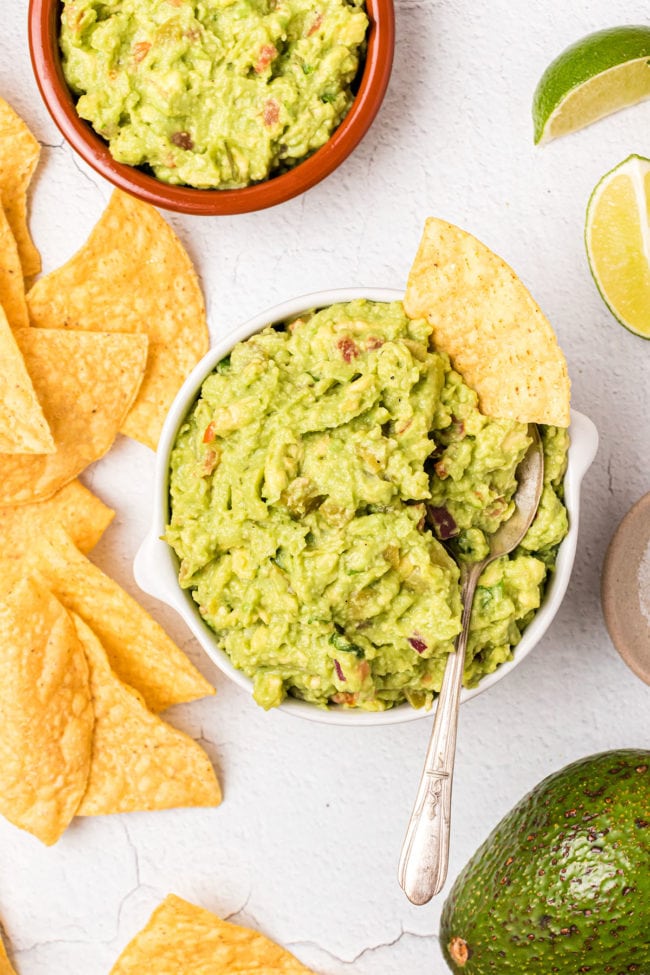 a white bowl of guac and chips