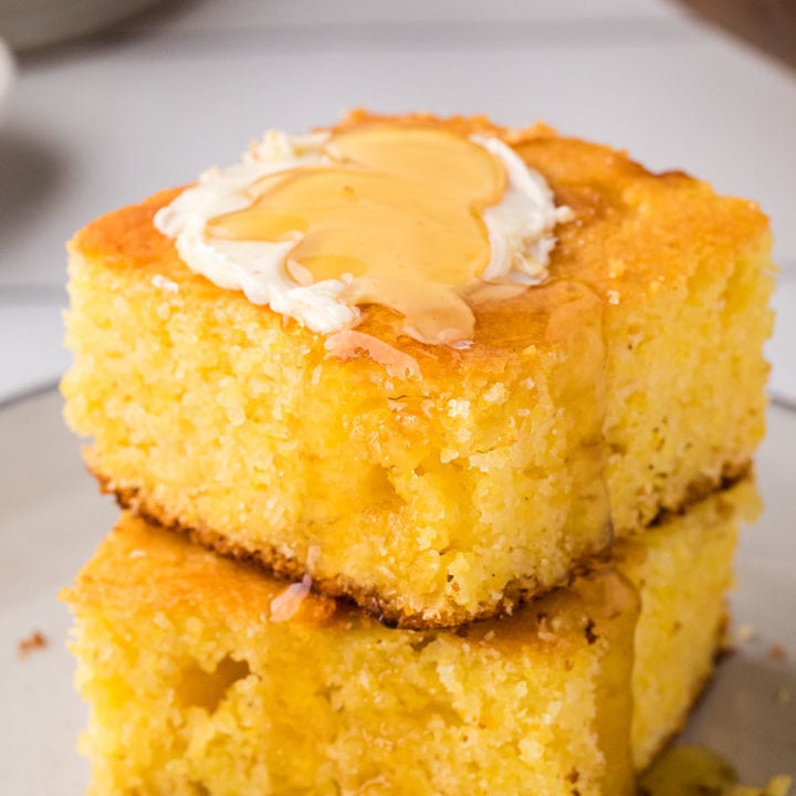 2 servings of cornbread stacked and topped with butter and honey