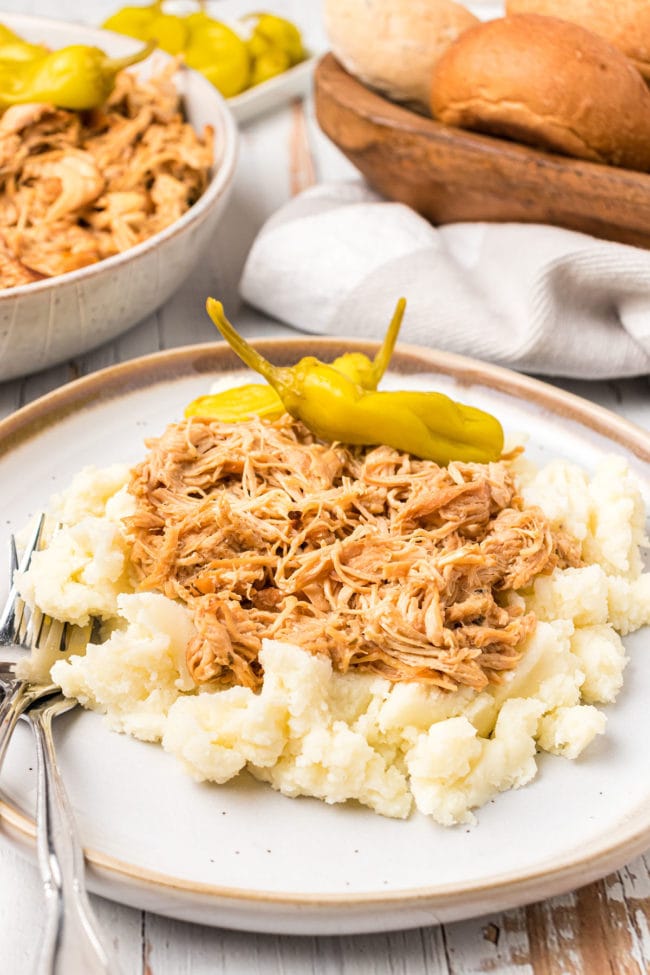 Mississippi shredded chicken on a plate of mashed potatoes