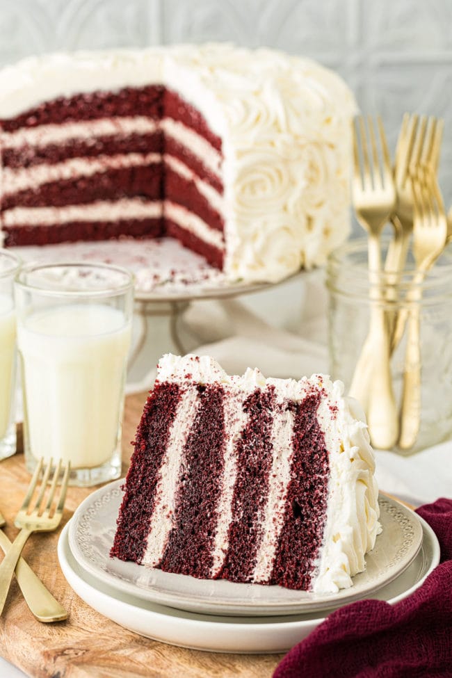 RED VELVET CAKE WITH CINNAMON BUTTERCREAM with a slice on a plate