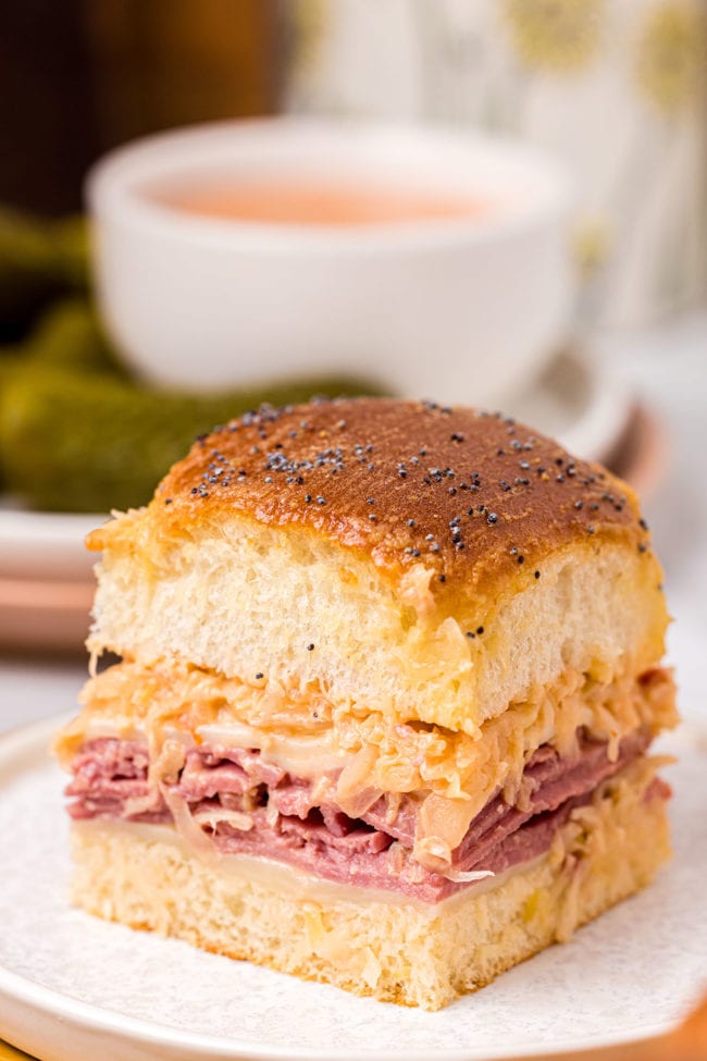 baked slider sandwich on a plate with a bowl of dipping sauce