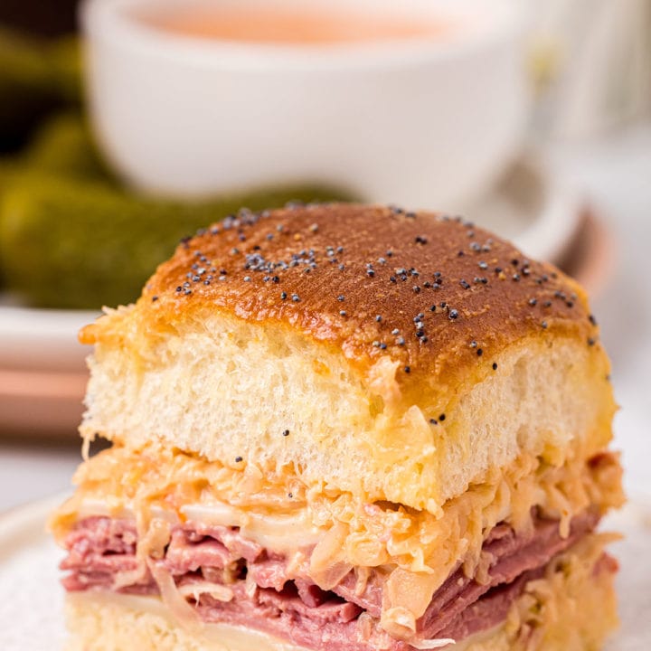 baked slider sandwich on a plate with a bowl of dipping sauce