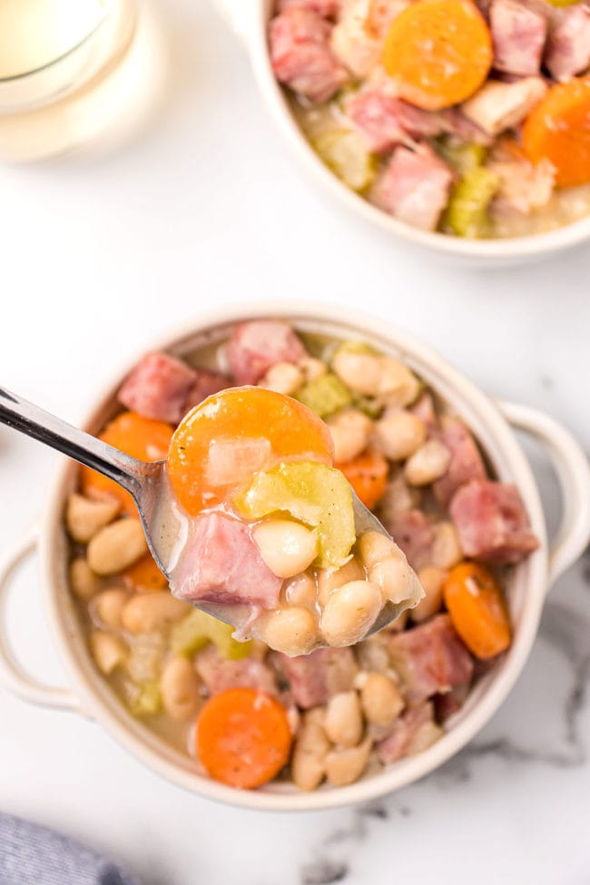 ham and beans with a spoon in a white bowl