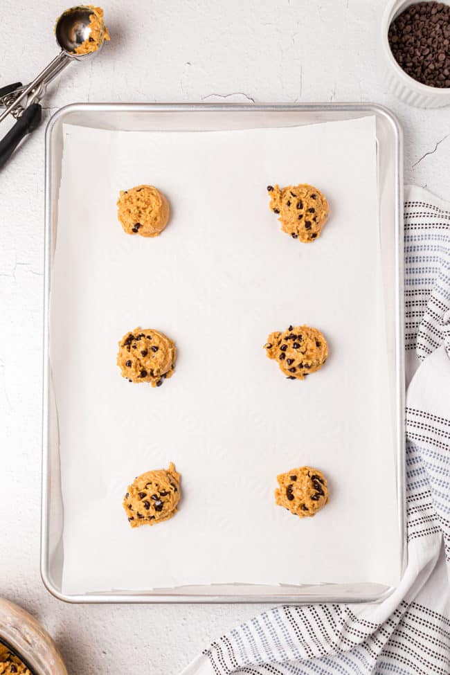 cookie dough balls on parchment lined baking sheet