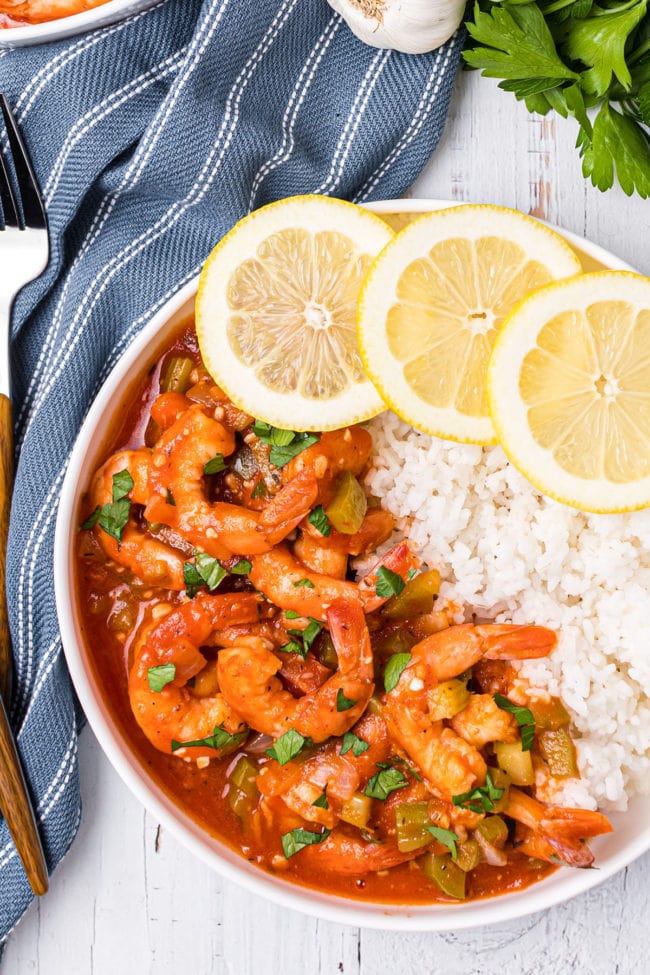 plate of shrimp creole with fresh lemon slices and white rice