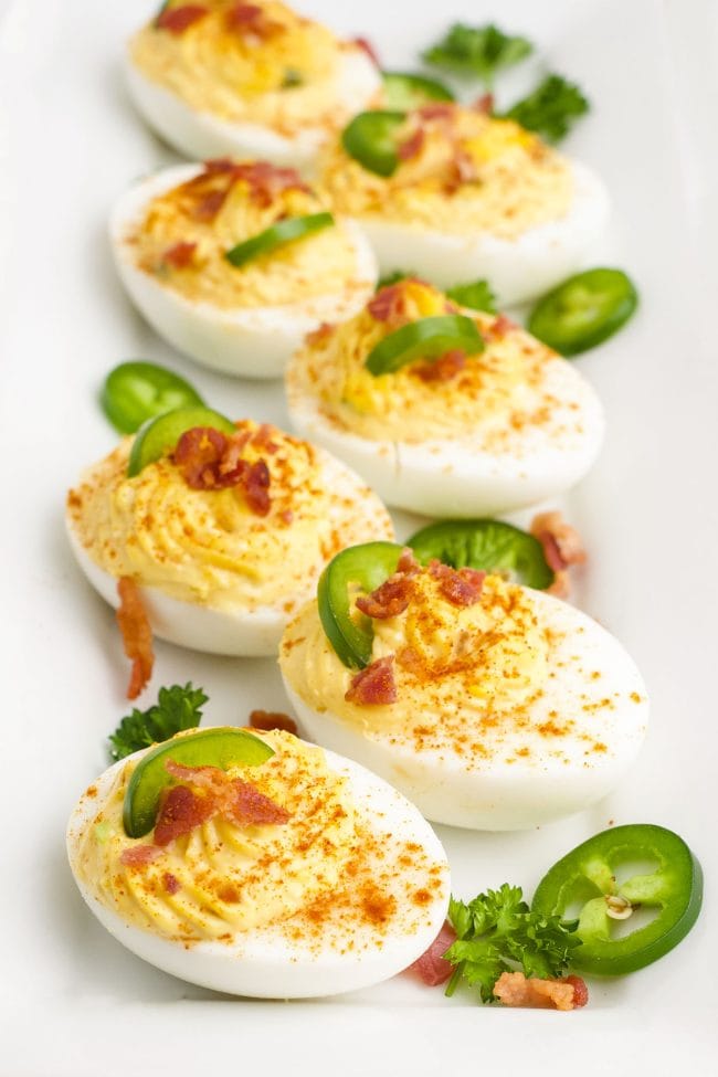 tray of deviled eggs topped with jalapeno slices