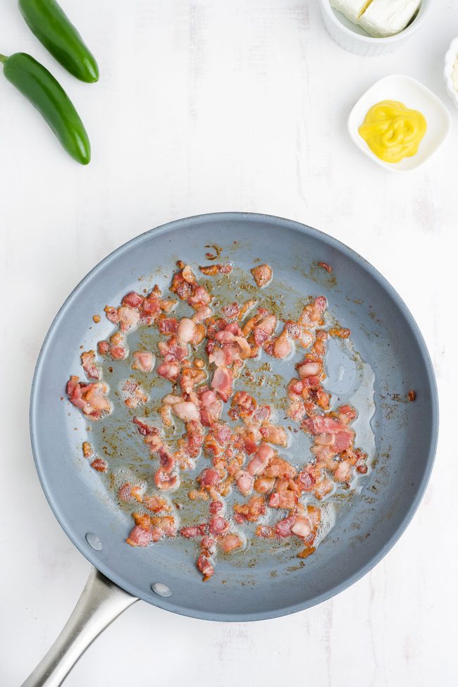 cooking bacon pieces in skillet