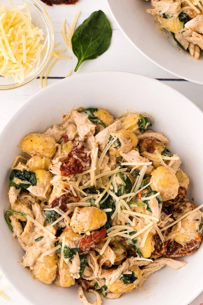 a bowl filled with creamy chicken gnocchi with sun dried tomatoes