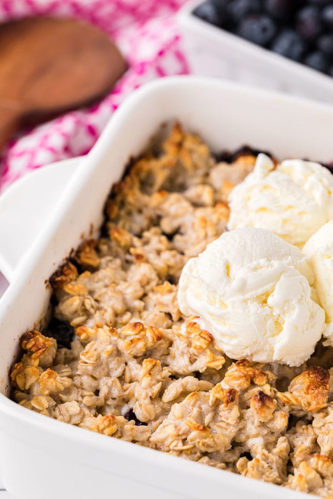 blueberry crisp with oats in a baking dish topped with ice cream