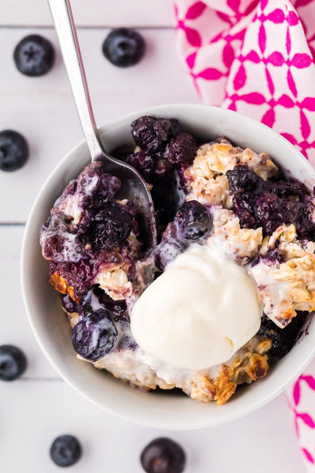 warm bowl of fruit crisp with oat topping and a scoop of ice cream
