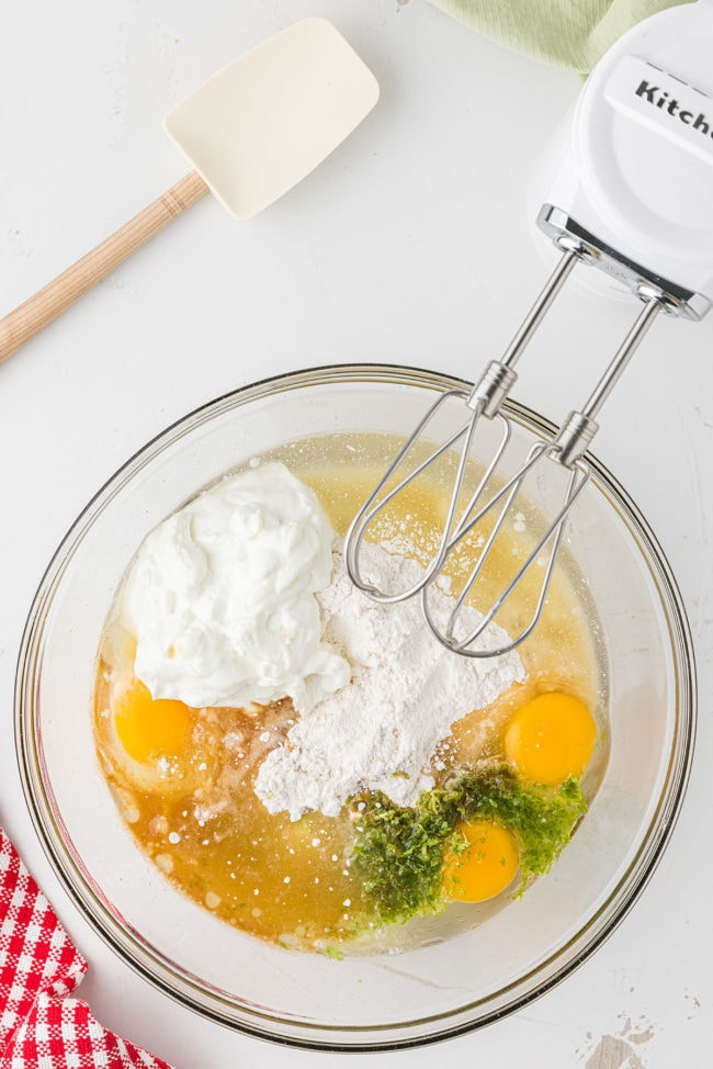 cake ingredients in glass bowl with hand mixer