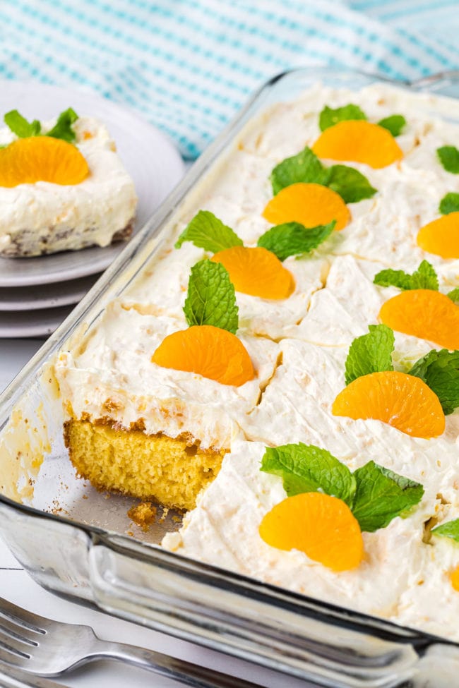 Mandarin Orange Cake in a glass dish with one serving missing