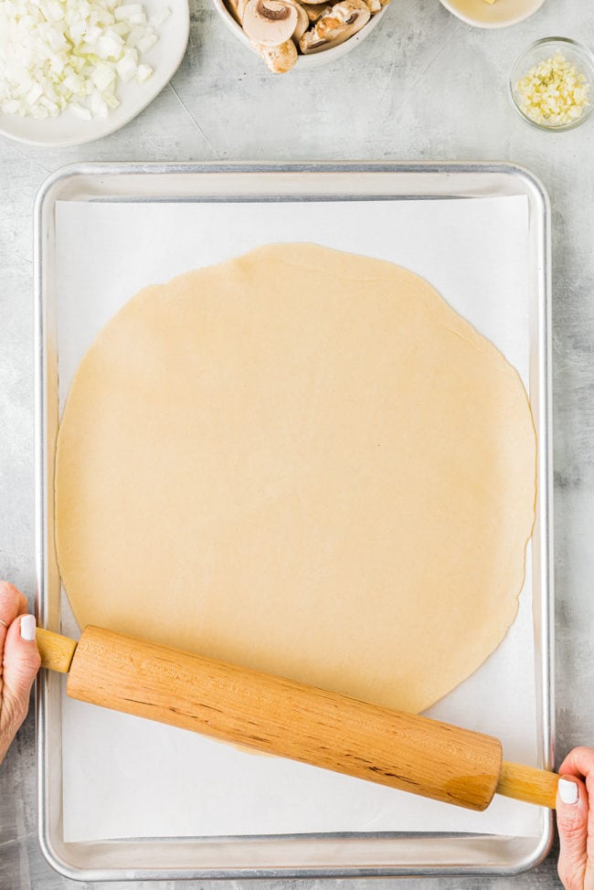 rolling out pie crust on a sheet pan
