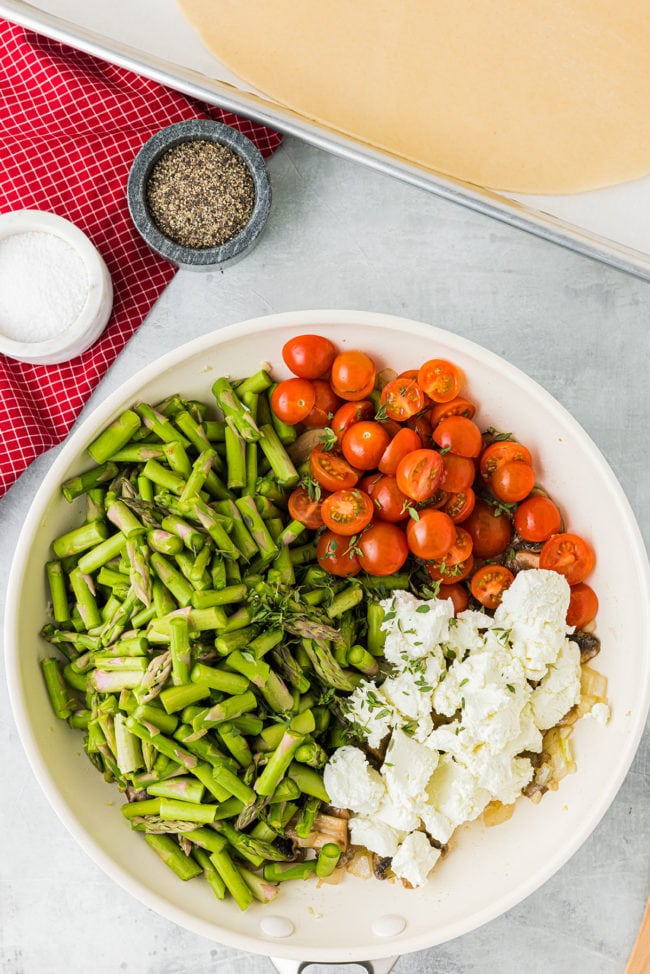 bowl full of asparagus, tomatoes, goat cheese