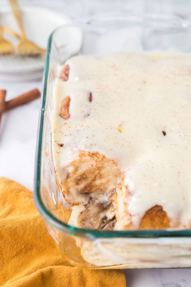 homemade cinnamon rolls with cream cheese icing in a baking dish