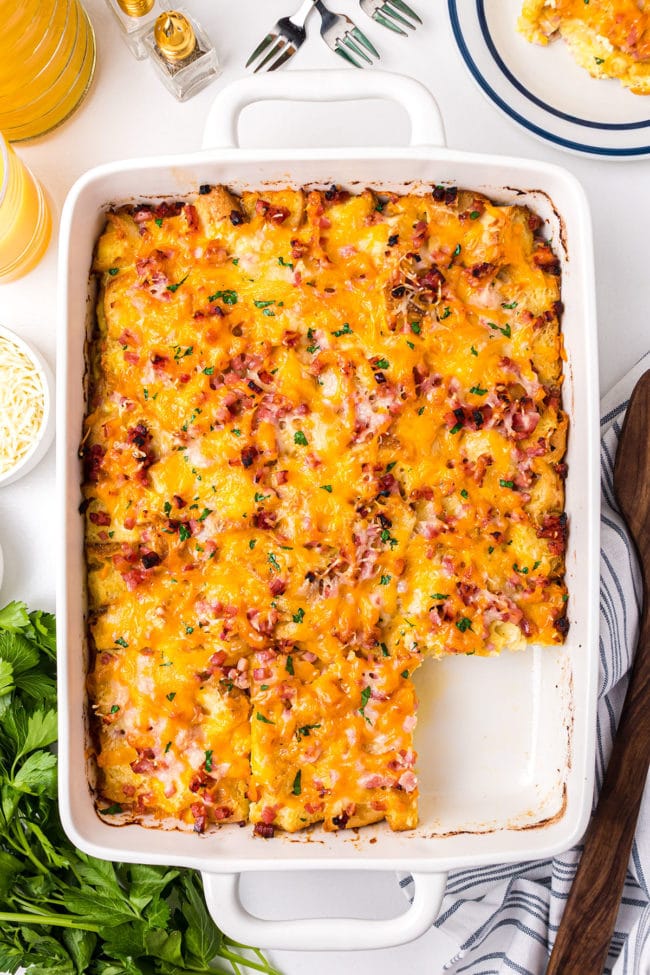 nglish muffin breakfast casserole in a baking dish with one serving missing.