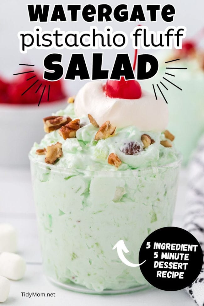 green fluff salad in a parfait cup with chopped nuts, whipped cream and cherries on top