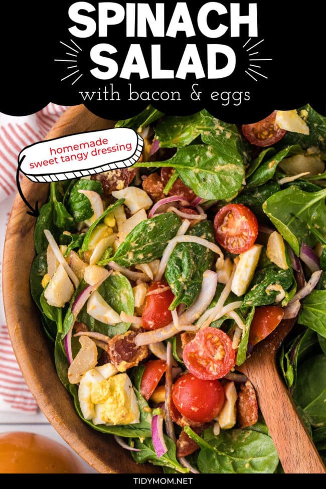 close up of spinach salad in a wood bowl