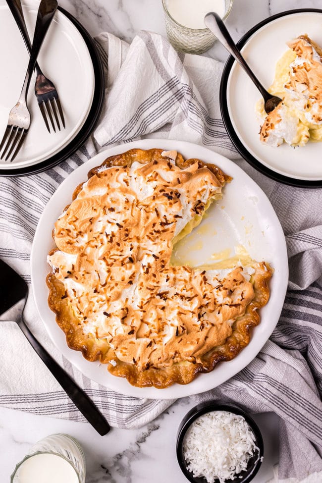 coconut pie with one serving on a plate with a fork