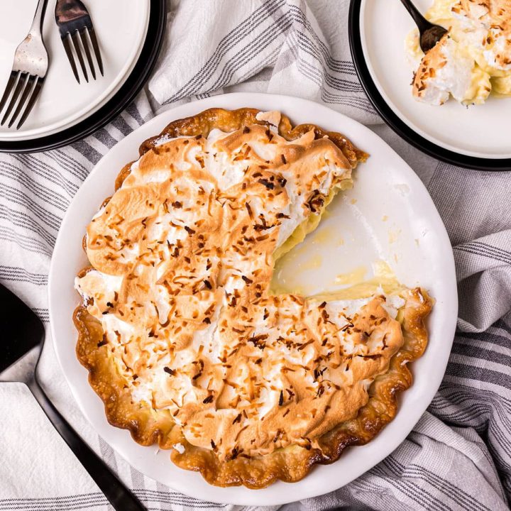 coconut pie with one serving on a plate with a fork