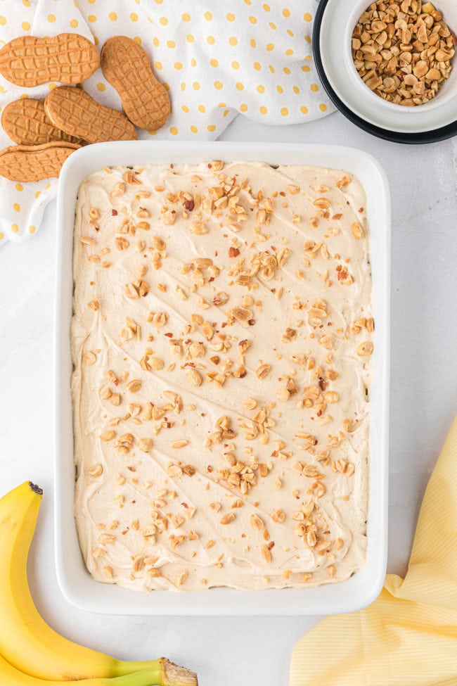 icebox cake with peanuts on top in a white dish