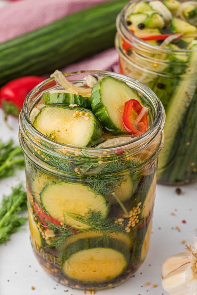 a widemouth canning jar with refrigerator pickles and fresh dill