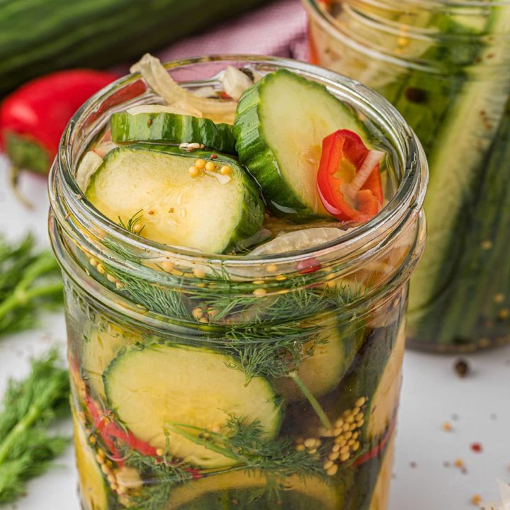 a widemouth canning jar with refrigerator pickles and fresh dill