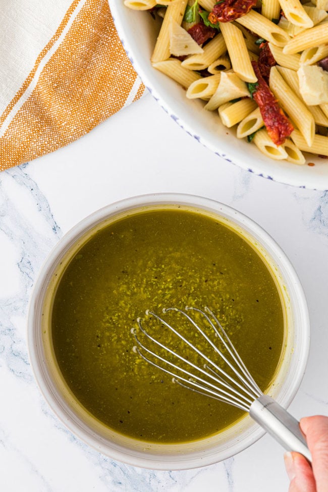 homemade Mediterranean salad dressing in a bowl with a wisk