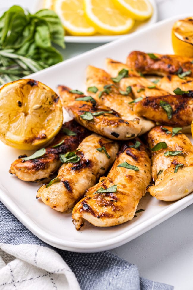 grilled lemon rosemary chicken tenders on a white platter