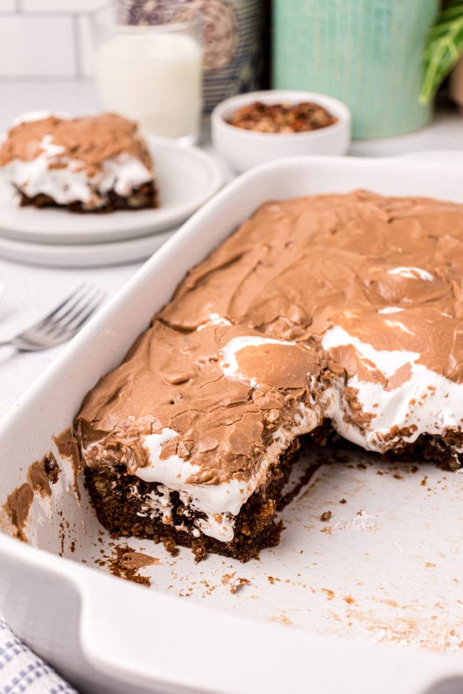 Mississippi mud cake in a white baking dish with several pieces gone.