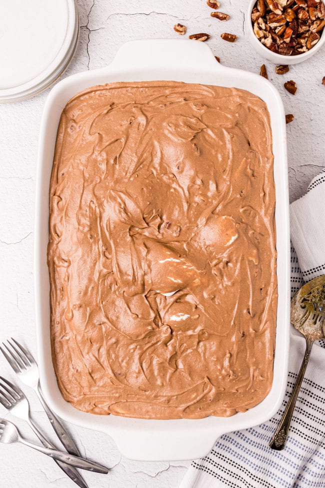 Mud cake step in a white baking dish with forks and cake server around it.